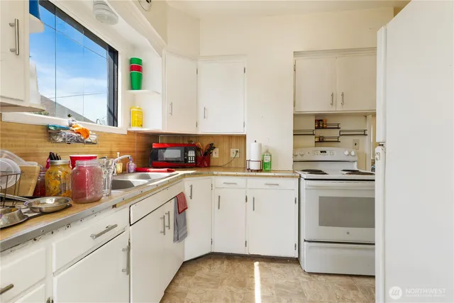 a kitchen with cabinets appliances a sink and a counter top