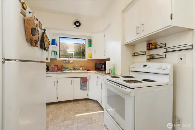 a kitchen with white cabinets and white appliances