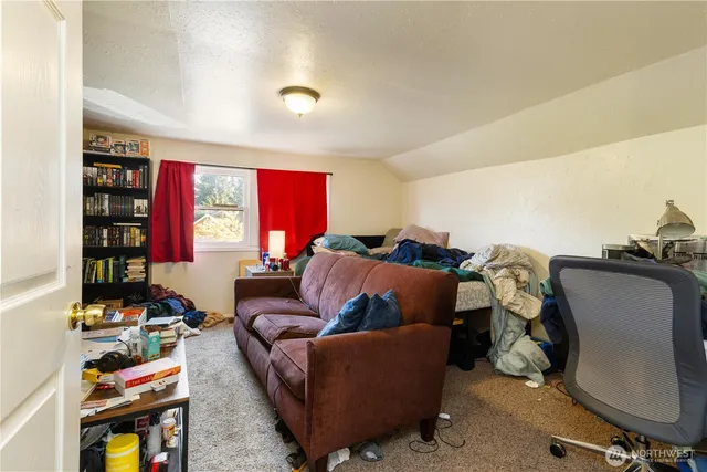 a living room with furniture a bookshelf and a window