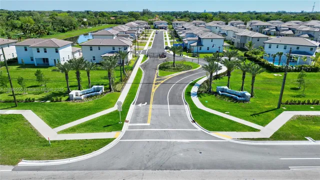 a view of a house with a big yard and large trees