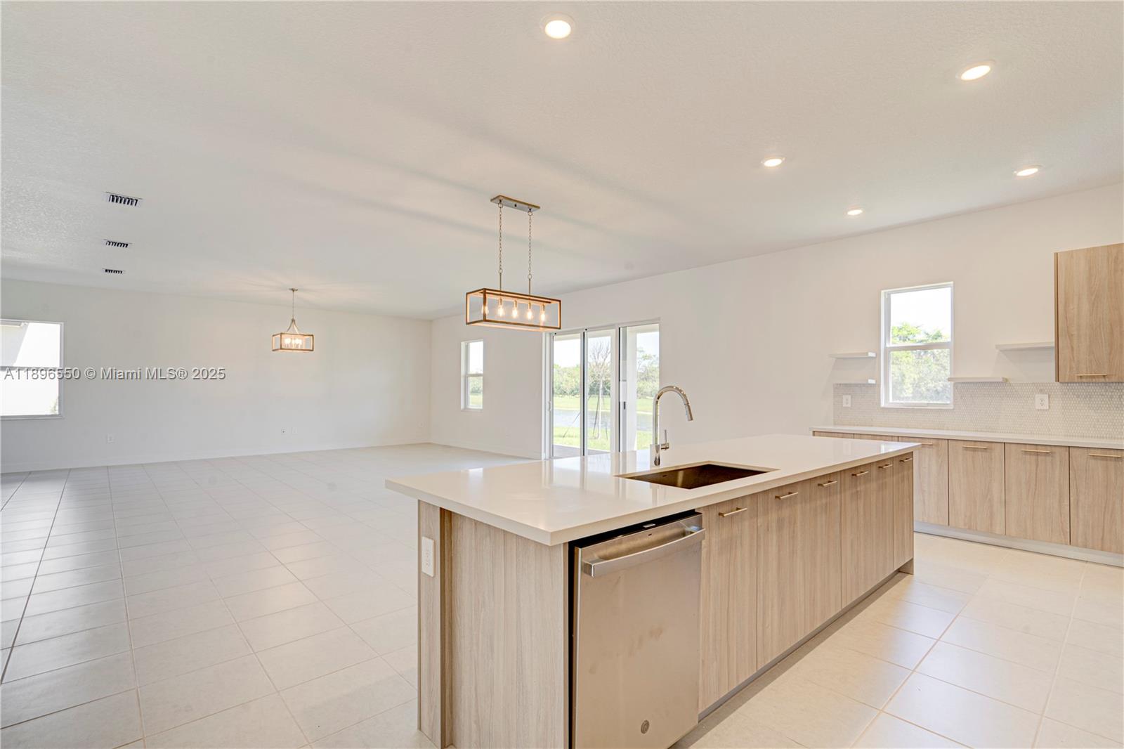 4390 Southwest 122nd Terrace Davie, FL 33330 - Photo 32 of 65 a kitchen with granite countertop a sink and white cabinets