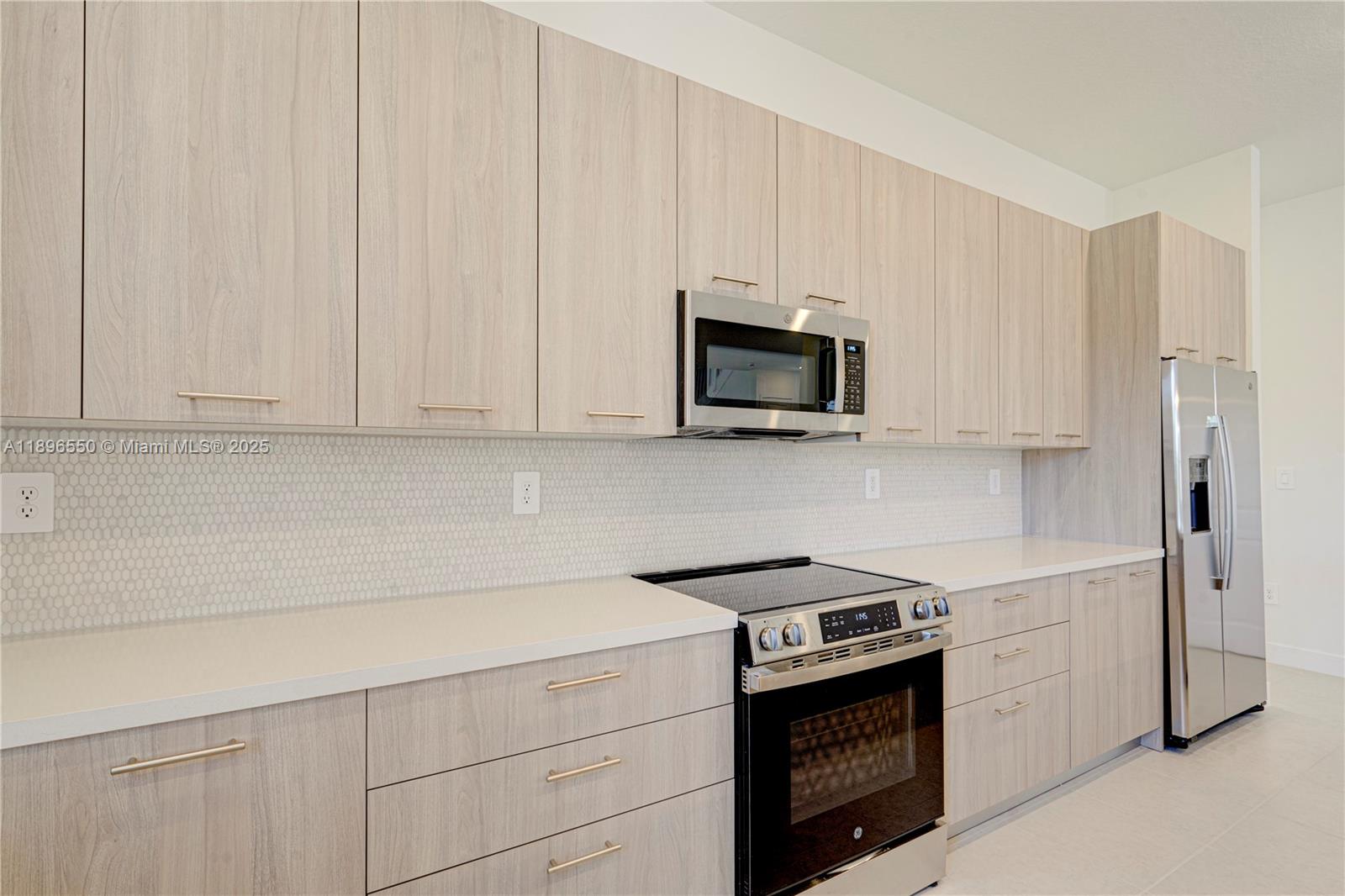 4390 Southwest 122nd Terrace Davie, FL 33330 - Photo 34 of 65 a kitchen with appliances a sink and cabinets