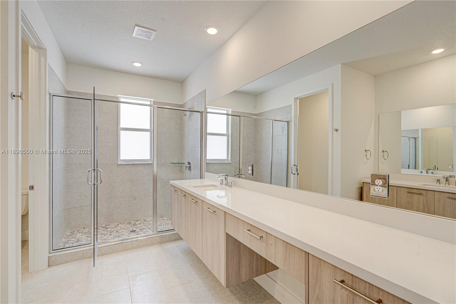 4390 Southwest 122nd Terrace Davie, FL 33330 - Photo 56 of 65 a spacious bathroom with a shower sink and mirror