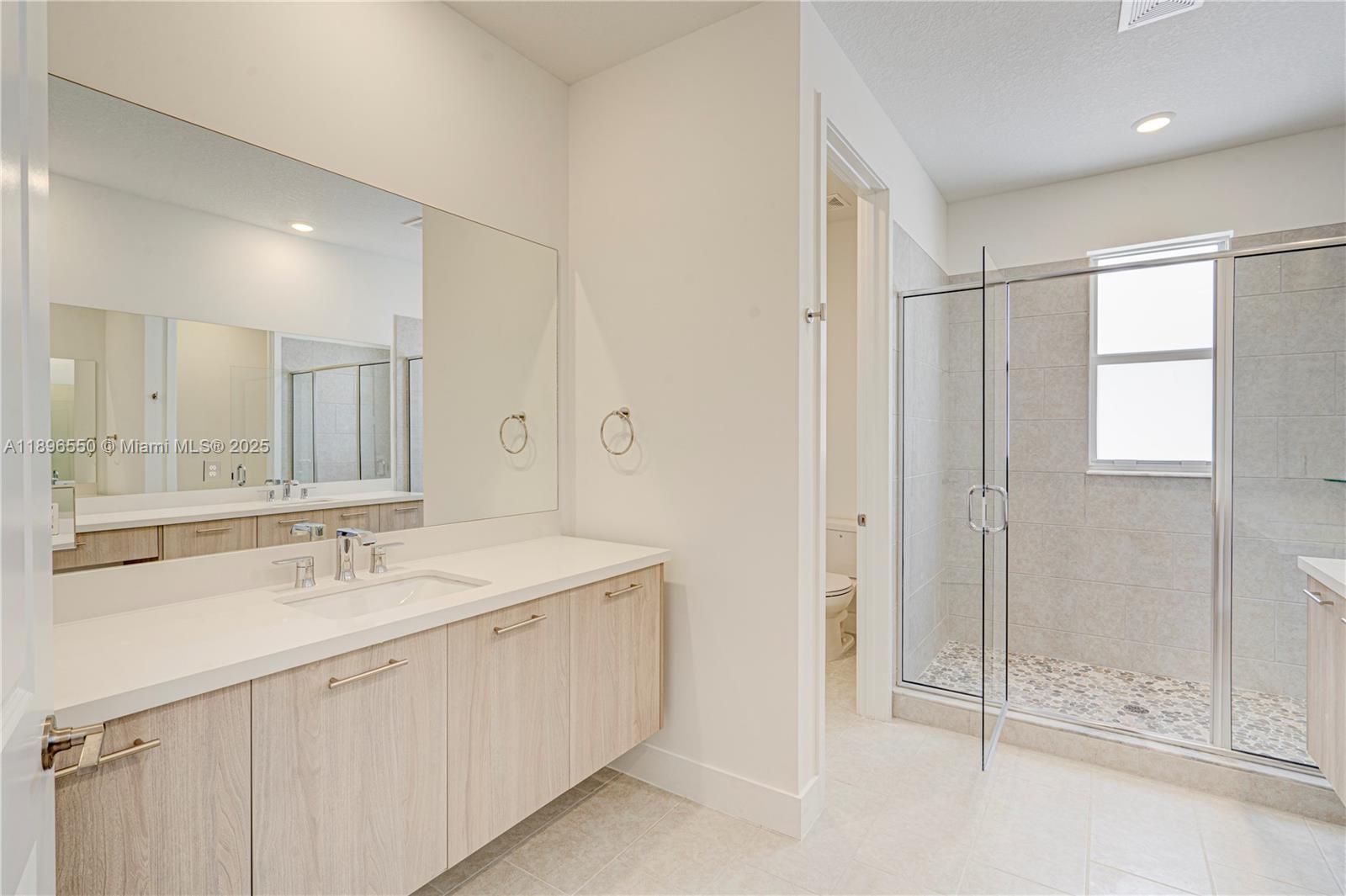 4390 Southwest 122nd Terrace Davie, FL 33330 - Photo 57 of 65 a bathroom with a shower sink and mirror