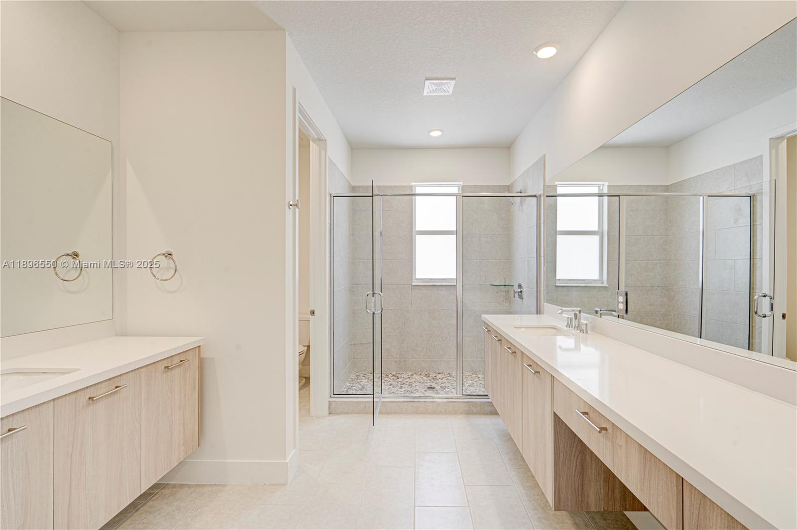 4390 Southwest 122nd Terrace Davie, FL 33330 - Photo 58 of 65 a large white bathroom with a double vanity sink a mirror and a bathtub