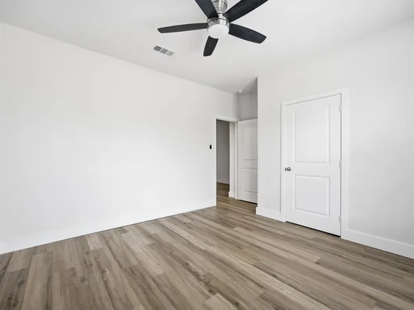 a view of a room with wooden floor and white walls