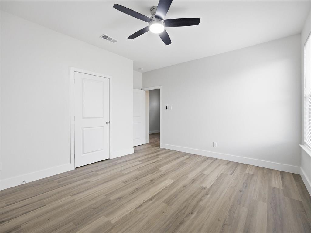 108 Couch Street Italy, TX 76651 - Photo 17 of 23 an empty room with wooden floor and a ceiling fan