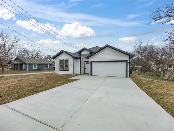 a front view of a house with a garden and trees
