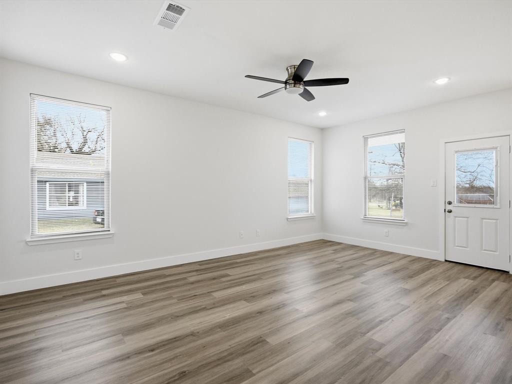 108 Couch Street Italy, TX 76651 - Photo 9 of 23 a view of an empty room with a window and wooden floor