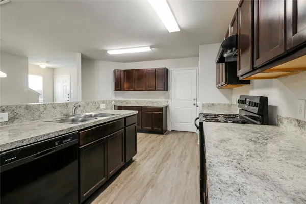 a kitchen with stainless steel appliances granite countertop a stove a sink and a microwave