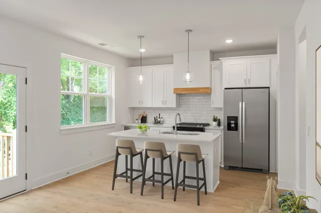 a kitchen with a table chairs refrigerator and microwave