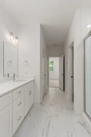 a spacious bathroom with a granite countertop sink a mirror and a shower