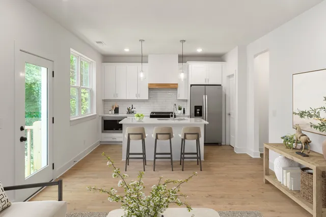 a large kitchen with kitchen island a large counter top space a sink stainless steel appliances and cabinets