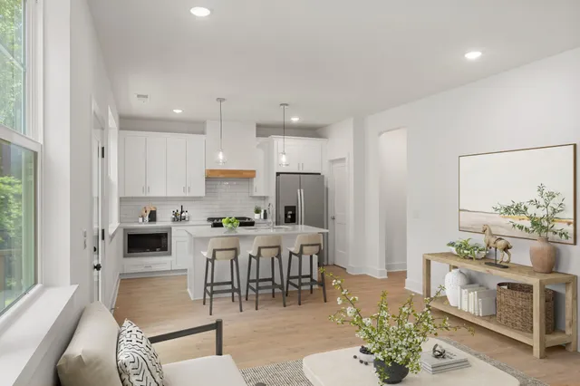 a living room with furniture a dining table and a chandelier