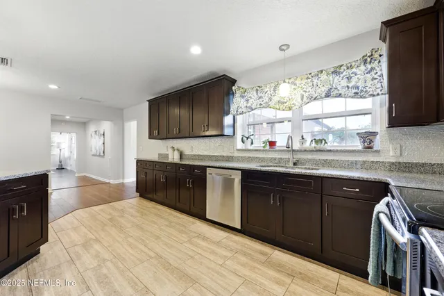 a kitchen with stainless steel appliances granite countertop a sink stove and cabinets