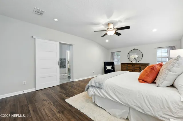 a bedroom with a large bed and a chandelier