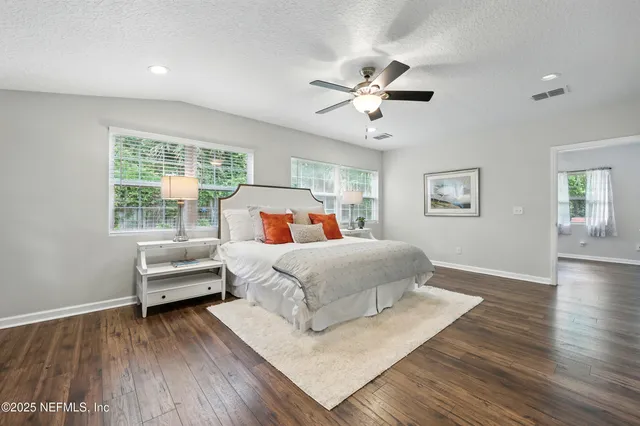 a bedroom with a bed and wooden floor