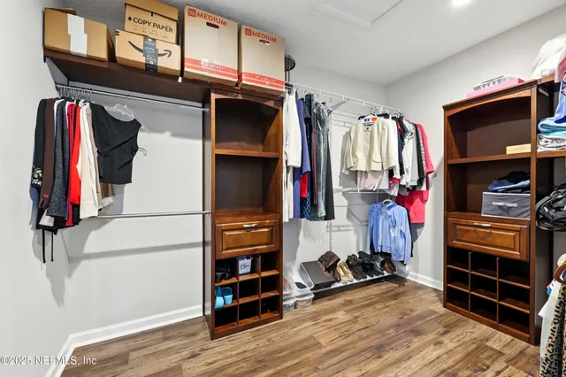 a view of walk in closet with clothes and shoes