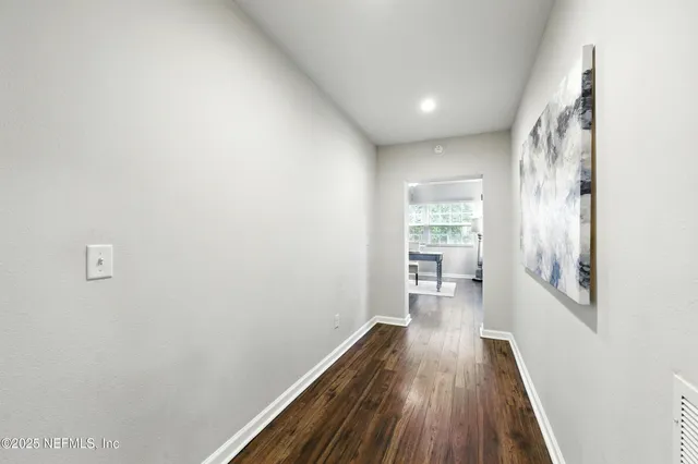a view of a hallway with wooden floor and a window