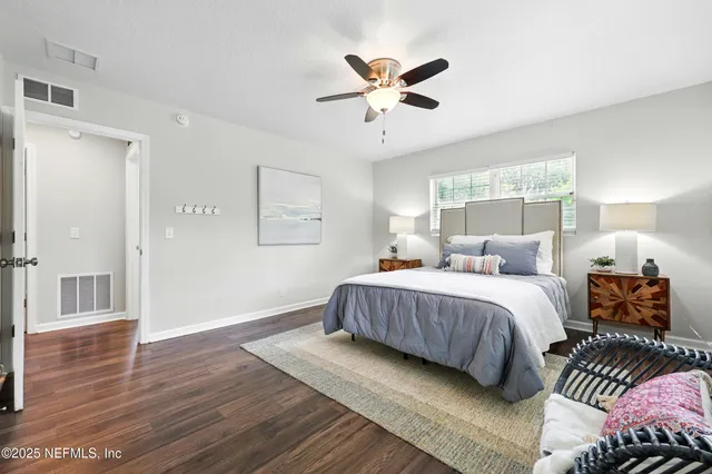 a bedroom with a bed and wooden floor