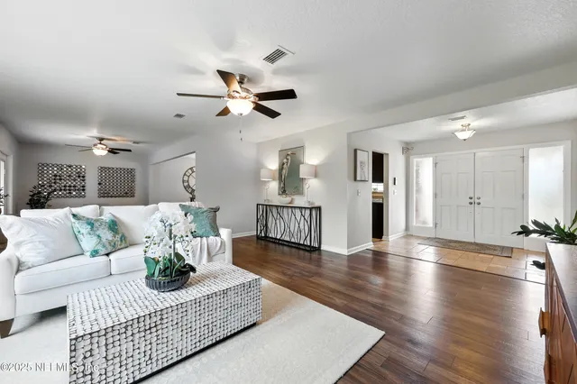 a living room with furniture and wooden floor