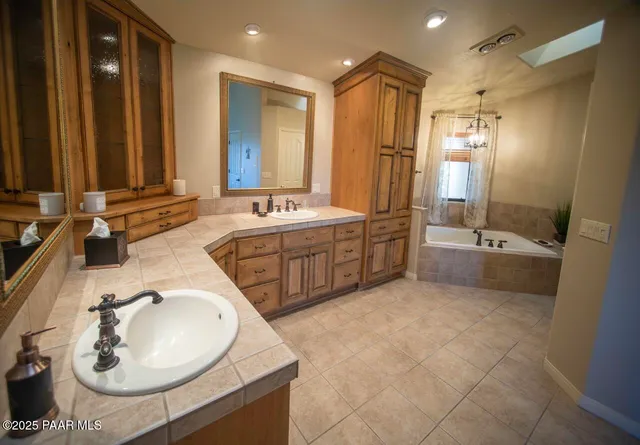 a bathroom with a double vanity sink a mirror and a bathtub