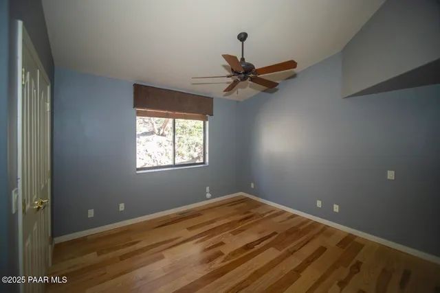 an empty room with a window and a fan