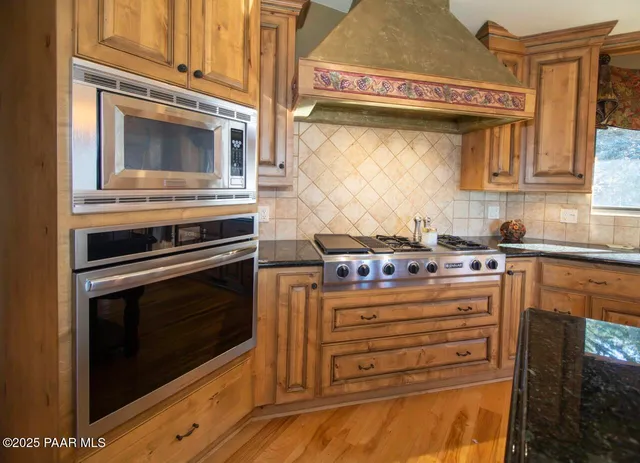 a kitchen with stainless steel appliances granite countertop a stove and a microwave