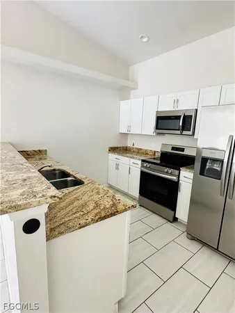 a kitchen with a sink a stove a refrigerator and cabinets
