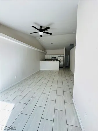 an empty room with a ceiling fan and window