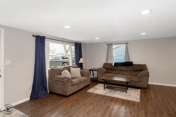 a living room with furniture and a wooden floor