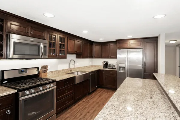 a kitchen with stainless steel appliances kitchen island granite countertop a stove a sink and a microwave