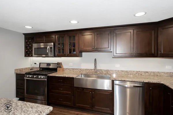 a kitchen with stainless steel appliances granite countertop a stove a sink and a microwave