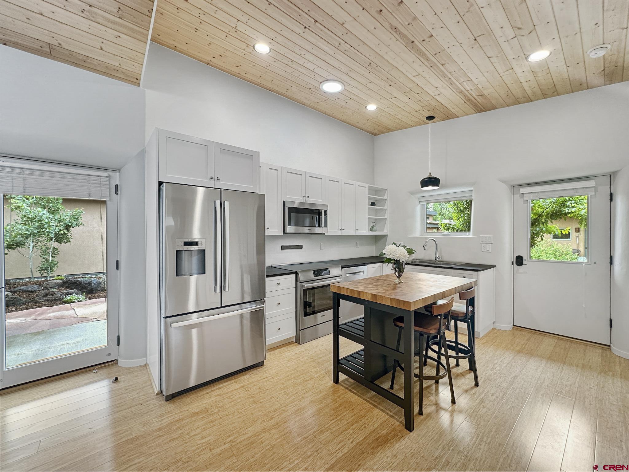 1200 3rd Street, Unit 6 Paonia, CO 81428 - Photo 6 of 34 a kitchen with stainless steel appliances a dining table chairs refrigerator and stove