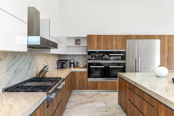 a kitchen with stainless steel appliances granite countertop a stove a sink and a refrigerator