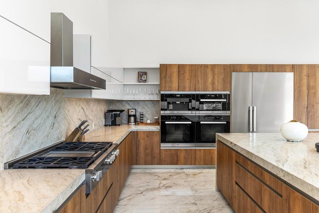 a kitchen with stainless steel appliances granite countertop a stove a sink and a refrigerator