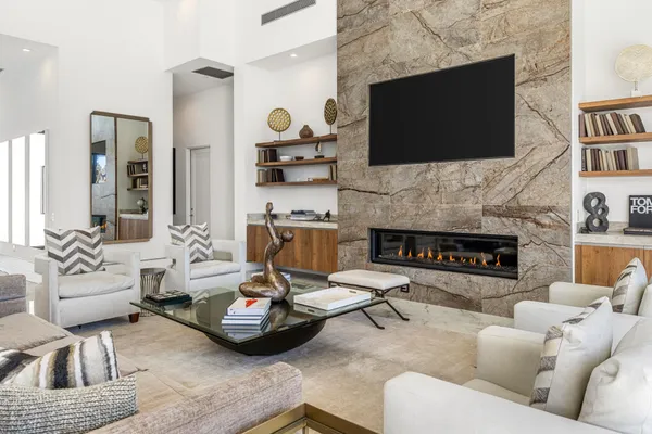 a living room with furniture a flat screen tv and a fireplace