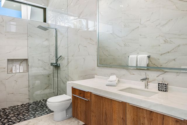 a bathroom with a sink toilet vanity and shower