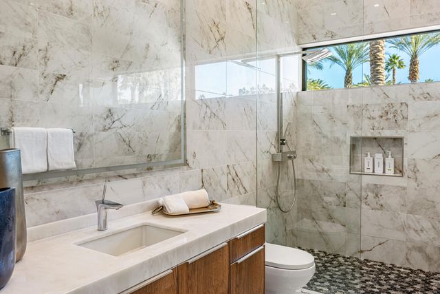 a bathroom with a sink toilet a mirror and shower