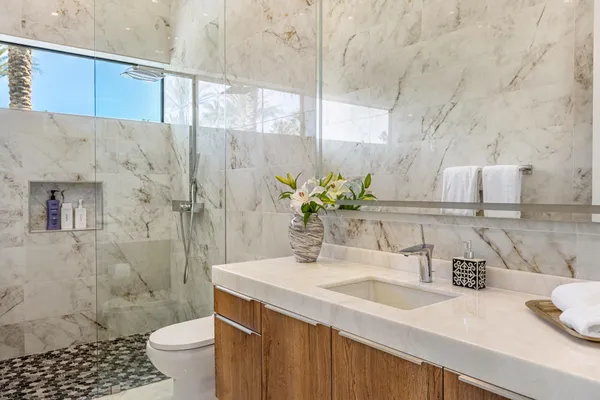 a bathroom with a granite countertop sink a toilet and shower