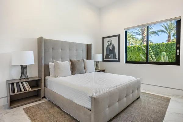 a bedroom with a large bed and a painting on the wall