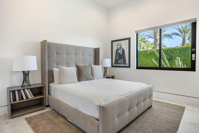 a bedroom with a large bed and a painting on the wall