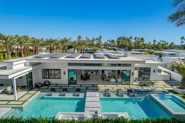 a view of a house with swimming pool and chairs