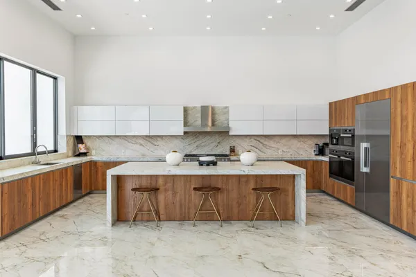 a kitchen with stainless steel appliances granite countertop a sink a stove and a refrigerator