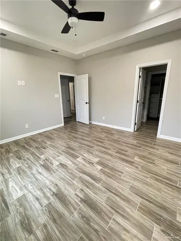 a view of empty room with wooden floor