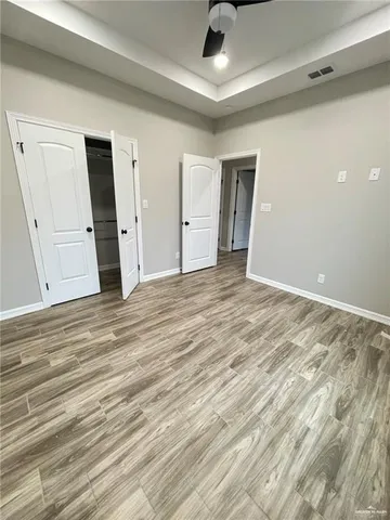 a view of empty room with wooden floor