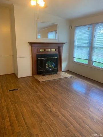 a view of an empty room with window and fire place