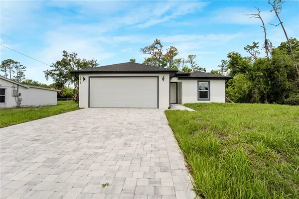 a view of a house with a yard and potted plants