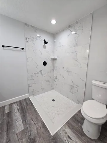 a bathroom with a toilet and a shower