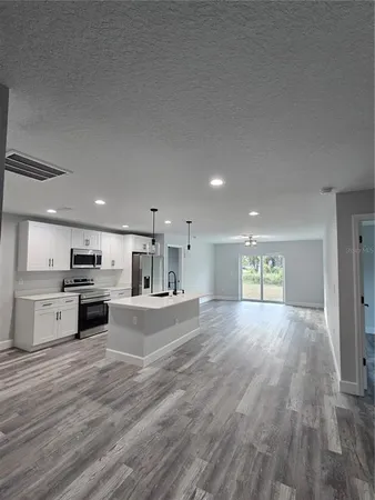 a view of kitchen with kitchen island microwave and stove